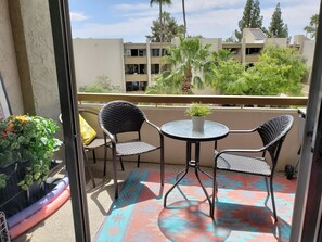 Balcony directly overlooking pool and palm trees