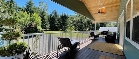 Covered deck with skylights, fan, furniture, and pellet grill.