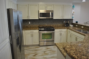 Stainless appliances and fully stocked with kitchen equipment