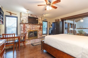 Queen size bed with table and chairs and dramatic fireplace.