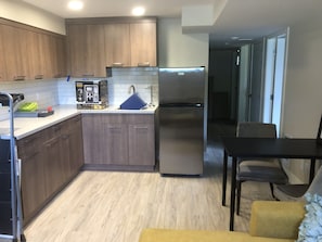 Kitchenette with refrigerator, microwave, sink, coffee maker