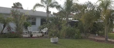 Street side patio, tropical gardens and driveway