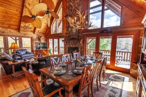 Main Level Living Area with Elk Mounted above Mantle on Floor-to-Ceiling Stone Fireplace, Custom Double Fan, Mountain Views