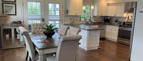 Dining table and six chairs adjacent to kitchen and patio