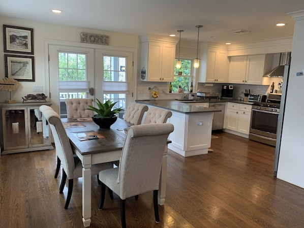 Dining table and six chairs adjacent to kitchen and patio