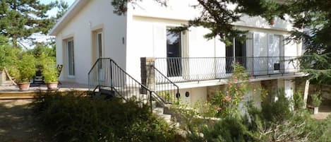 Vue d'ensemble,façade,terrasse en bois, jardin arbore,exposition Sud Ouest.