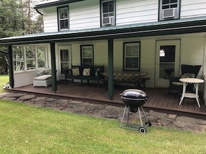 Front of farmhouse features spacious porch w/ picnic table, BBQ grill, etc.