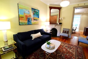Front living area w/ historic marble mantel and original artwork in oil.