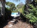 Fenced pool and patio area with garden/ lounges/chairs/tables/natural gas grill