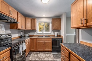 Full Kitchen secondary view. Microwave located to the right on the counter. Main floor, with access to dining room