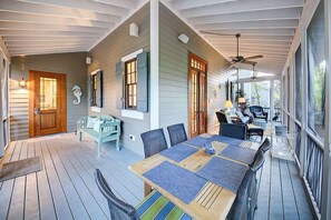 The back porch is screened in and has a dining table and conversational seating