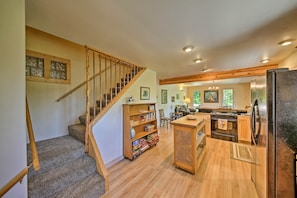 The open floor plan is filled with forested vistas and bright natural light.