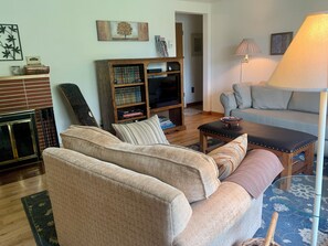 A living room view from the front door toward the hall and bedrooms.