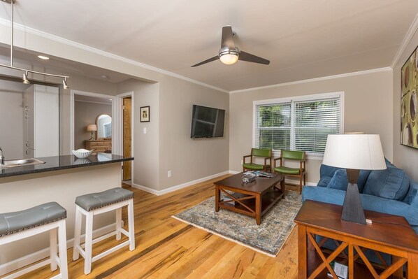 Open living room with SMART tv that leads into the beautiful kitchen