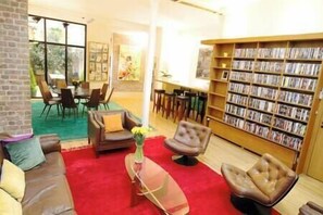 View of the large living room, kitchen, dining room and its DVD library