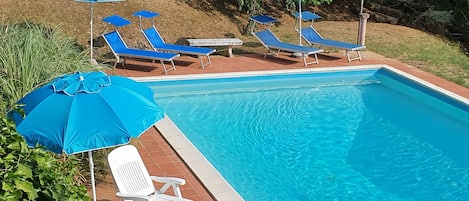 Large swimming pool with outdoor shower and lots of sunchairs