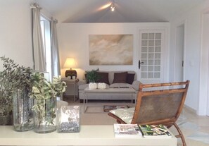 Bright living room with views to the garden, terrace and the ocean.