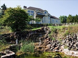 Back of estate daytime with cascading water fall.
