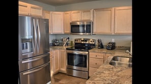 Fully stocked kitchen - complete with granite countertops & stainless appliances