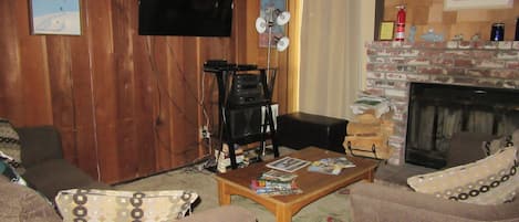 Living room includes fireplace, two couches, big screen tv.

