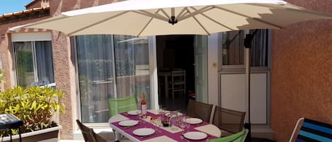 Terrasse avec salon de jardin , grand parasol et barbecue