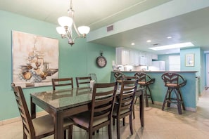 The dining table seats six with extra seating at the kitchen bar.
