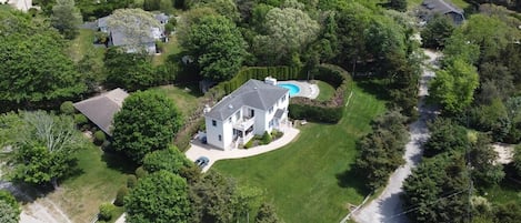 House and pool sit on a large, green piece of property. Perfect for lawn games!