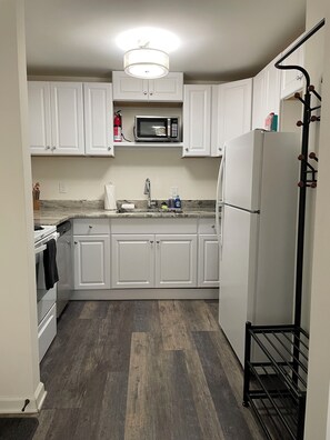Kitchen with full-sized refrigerator, oven, cooktop, and microwave.