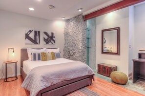 The 1st bedroom is an architectural delight with exposed stone and steel beams