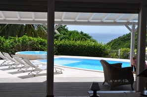La piscine avec jacuzzi et la mer en fond