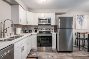 Modern kitchen with Quartz countertops and new stainless appliances.