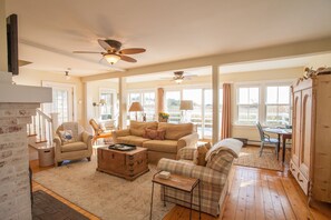 Bright & open living room with access to large outside deck overlooking marsh.