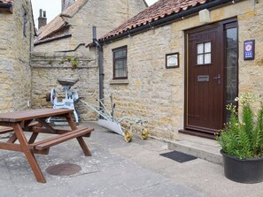 Paved patio with outdoor furniture at entrance | Cow Pasture Cottage - Studley House Farm Cottages, Ebberston, near Scarborough