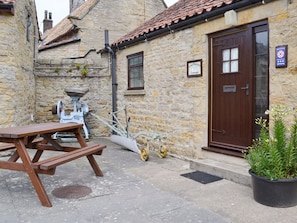 Paved patio with outdoor furniture at entrance | Cow Pasture Cottage - Studley House Farm Cottages, Ebberston, near Scarborough