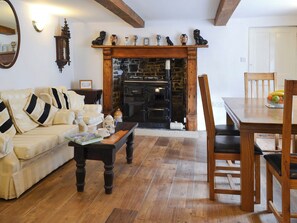 Dining room with oil Rayburn and beams | Knotty Corner Cottage, Fairy Cross, near Bideford