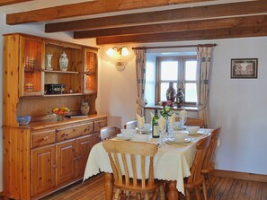 The farmhouse style table and dresser complement the dining area’s wooden floor and exposed beams | Coachmans Cottage, White Cross, near Newquay