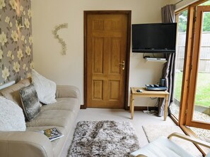 Homely living room with French doors to patio | Blackthorn Cottage, Swan Pool, near Falmouth