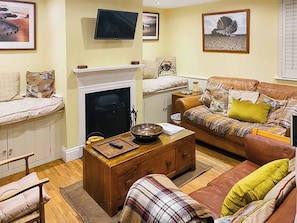 Cosy living room with open fire and wooden floor | Pebble Cottage, Aldeburgh