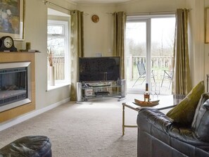 Spacious living area with patio door to decked area | Willow - Thornbury Holiday Park, Woodacott, near Holsworthy
