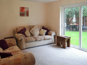 Living room with sliding patio doors leading to garden | Hideaway Cottage, Kingsgate, near Broadstairs