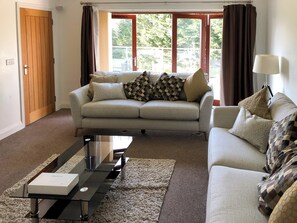 Living area with doors to the balcony | Hafan Dawel, Stepaside, near Saundersfoot