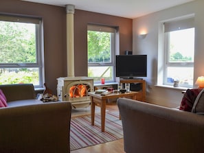 Spacious living and dining room with wood burner | Tre Anna Lodge, Dwyran, near Llanfairpwllgwyngyll