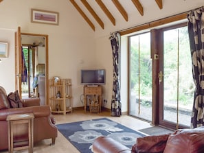 Airy living room with door to patio and garden | The Cotes, Upper Welland, near Malvern