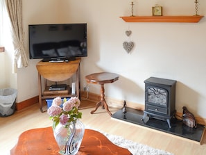 Living room with electric log burner | Seashell Cottage, Fishertown, Nairn