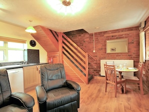 Comfortable leather chairs and wooden floor in the living area | Yarlington Mill - The Old Kennels Holidays, Ledbury