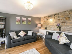 Living room with exposed stone feature wall and wood flooring | The Old Church, Alton, near Chesterfield