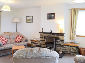 Living area with comfortable furniture and feature fireplace | John O&rsquo; Groats - Horseman&rsquo;s Cottage - Watermill Cottages, John O&rsquo; Groats