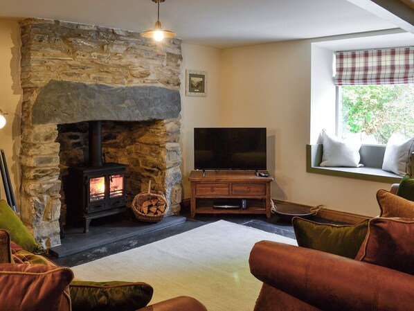Cosy living room with wood burner and slate floor | Maybill Cottage, Cwm Penmachno, near Betws-y-Coed
