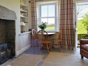 Living room with wood-burner and door to garden | Gardenwell Cottage, Burtersett, near Hawes