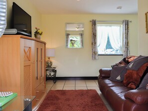 Comfortable living room with tiled floor | Hunter’s Cottage - Llwyn Ffynnon, Y Ffôr, near Pwllheli